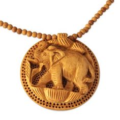 an elephant carved in wood on a beaded necklace