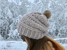 a woman wearing a knitted hat with a pom - pom