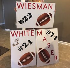 two signs with footballs and numbers on them are displayed in front of a woman