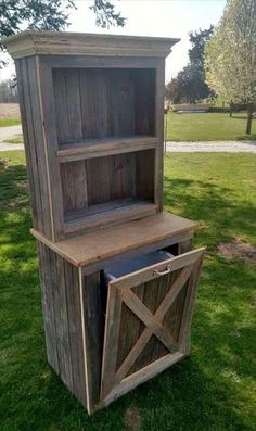 an old wooden book shelf with a trash can in the bottom and door on top