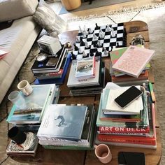 a coffee table filled with books next to a fire place