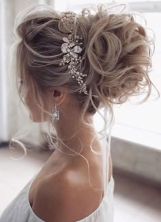 the back of a woman's head with long hair and flowers in her hair