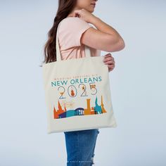 a woman carrying a tote bag with various things on it