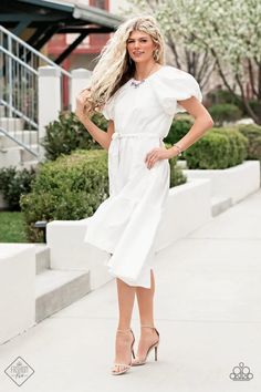 a woman in white dress posing for the camera