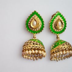 - 18kt yellow gold plating on silver, copper, and brass metal that is lead and nickel free making it body safe - Antique green enamel with pearl drops jhumka with pearl stud - Pushback latch closure - Lightweight and comfortable to wear - Stylish earrings are a traditional design - Elegantly boxed to be given as a gift, or easily stored to be ready for your next occasion Green Teardrop Enamel Jewelry, Green Dual-tone Chandbali Jewelry, Ceremonial Meenakari Enamel Jewelry, Elegant Green Jhumkas For Festive Occasions, Elegant Green Festive Jhumkas, Green Enamel Jewelry For Wedding, Green Earrings For Festive Occasions, Green Festive Earrings For Festivals, Festive Green Earrings For Festivals