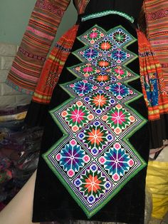 a woman's black dress with colorful designs on it