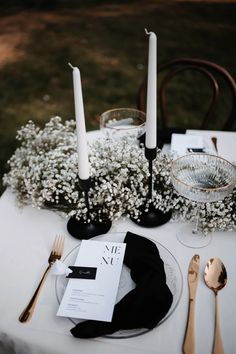 the table is set with silverware, candles and napkins for an elegant dinner