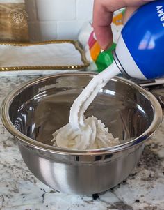 a person is pouring cream into a bowl