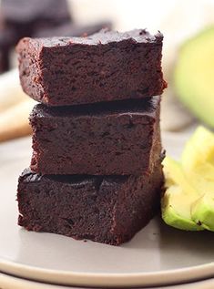 three brownies stacked on top of each other next to an avocado