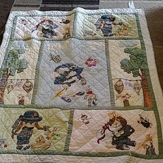 a quilted blanket with pictures of people and animals on it