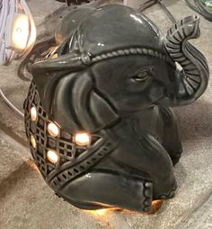 an elephant statue sitting on top of a counter next to a light bulb and some wires