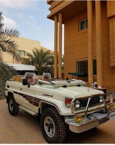 a white truck parked in front of a tall building