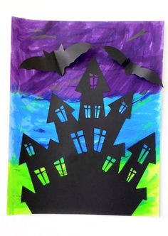 a paper bag with some cut out houses on it and bats flying over the house