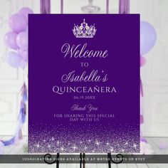 a welcome sign with purple and white confetti on the bottom, in front of balloons