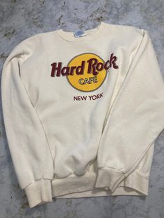 "Vintage 90's Hard Rock Cafe New York crewneck sweater. Made in USA with the custom Hard Rock Tag. As far as these go this is certainly the grail of hard rock merch, as every other cafe wants to be like the New York one. White and colors are very clean with two minor small stains pictured above. Size: Medium Pit to Pit: 19.5\" Shoulder to Bottom: 21.5\"" Band Logo Crew Neck Sweatshirt For Streetwear, Streetwear Crew Neck Sweatshirt With Band Logo, Retro Crew Neck Sweatshirt For Concerts, Casual Crew Neck Sweatshirt With Band Logo, Hard Rock Cafe Outfit, New York Crewneck, Cafe New York, New York Vintage, Rock Cafe