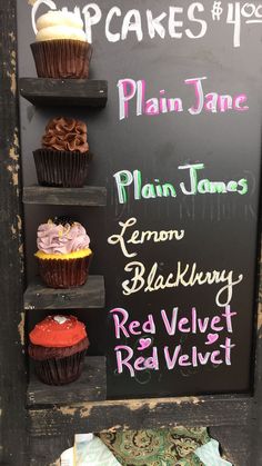 cupcakes on display in front of a chalkboard sign