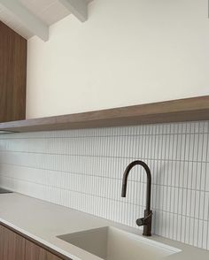 a kitchen counter with a sink and faucet in the middle, next to a window