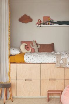 a child's room with a bed, desk and toys on the shelves in it