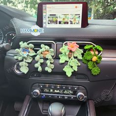 stuffed animals are placed in the center console of a car, while an ipod is attached to the dash board