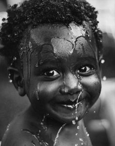 a black and white photo of a child with makeup on