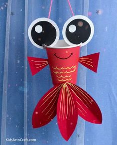 a paper fish hanging from a string with eyes on it's head and nose