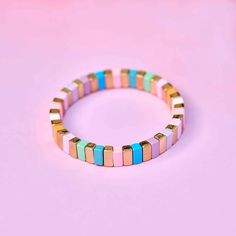 Pretty in pastel all summer long. The Bright Tides Bead Stretch Bracelet features enamel-plated beads in nine pantone summery shades. The total length of the bracelet is 6.25''. Easy On and Off One size fits most, easy to slip on and off. - Strung on thick elastic nylon cords- Beads are 12mm (L), 8mm (H)- Gold beads are brass base with gold plating- Total length of bracelet: 6.25 inches Tech Accessories Gadgets, Cloud Stickers, Pura Vida Bracelets, Enamel Beads, Chapstick Holder, Enamel Bracelet, Girly Jewelry, 50th Gifts, Beaded Stretch Bracelet