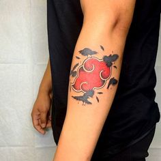 a person with a tattoo on their arm holding a red heart and two black birds