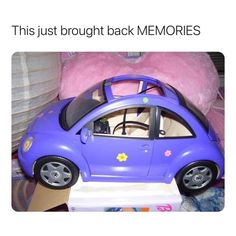 a purple toy car sitting on top of a white box next to a pink stuffed animal