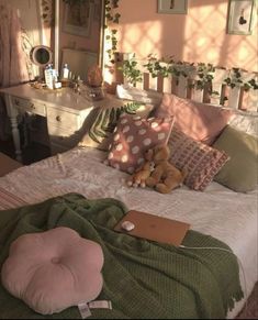 there is a bed with many pillows on it and a teddy bear in the middle