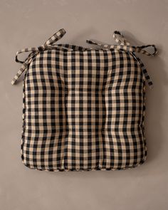 a black and white checkered pillow hanging on the wall