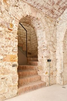 an old brick building with stairs leading up to the second floor and another room in the background