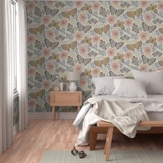 a bedroom with a bed, nightstands and flower wallpaper