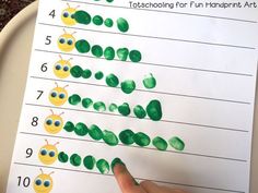 a child's hand is pointing at a printable caterpillar