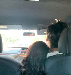 a man and woman sitting in the back seat of a car