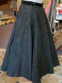 "1950's, 26\", black flocked taffeta circle skirt, with a black velvet waist band, with a black net under petticoat. Skirt is fastened on left side with a zipper and black button atop zipper. Label reads \"Rosecrests\" NY. Measurements: waist 26\" waist to hem 31\" width at bottom 128\" of skirt Condition: excellent" Vintage Black Skirt For Costume Party, Vintage Flared Skirt For Evening, Black Full Skirt Petticoat For Wedding, Costume Full Gathered Skirt, Black Full Skirt Petticoat For Party, Vintage Full Skirt For Costume, Costume Full Skirt With Gathered Details, Fitted Black Long Petticoat, Vintage Full Skirt Petticoat For Costume