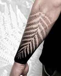 a man's arm with a fern tattoo on it