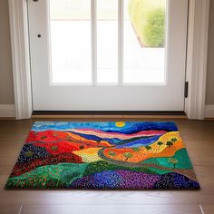 a colorful rug on the floor in front of a white door with an open window