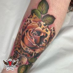 a tattoo with a rose and leopard print on the arm, done by an artist