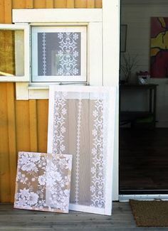 there are three pictures on the front porch and one is in an open window with white lace