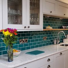 a vase with flowers in it sitting on a kitchen counter