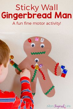 a young boy is making a gingerbread man craft with paper and magnets on the wall