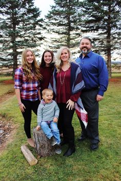 a family posing for a photo in front of some trees