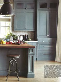 an image of a kitchen setting with blue cabinets and stools on the countertop