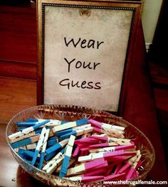 a basket filled with baby shower games sitting on top of a wooden table next to a sign that says wear your guess