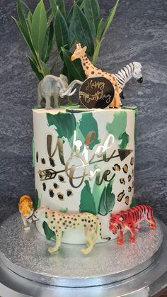 a birthday cake decorated with animals and plants