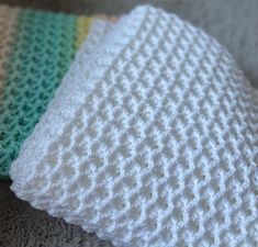 three crocheted blankets sitting on top of each other in different colors and sizes