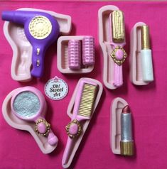 there are many different types of hair accessories on the pink tablecloth, including combs, scissors, and other items