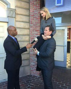 a man in a suit and tie is being interviewed by a woman wearing a striped shirt