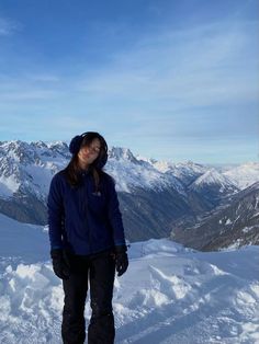 a woman standing on top of a snow covered slope