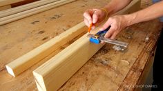 a person using a pair of scissors to cut up wood planks on a workbench